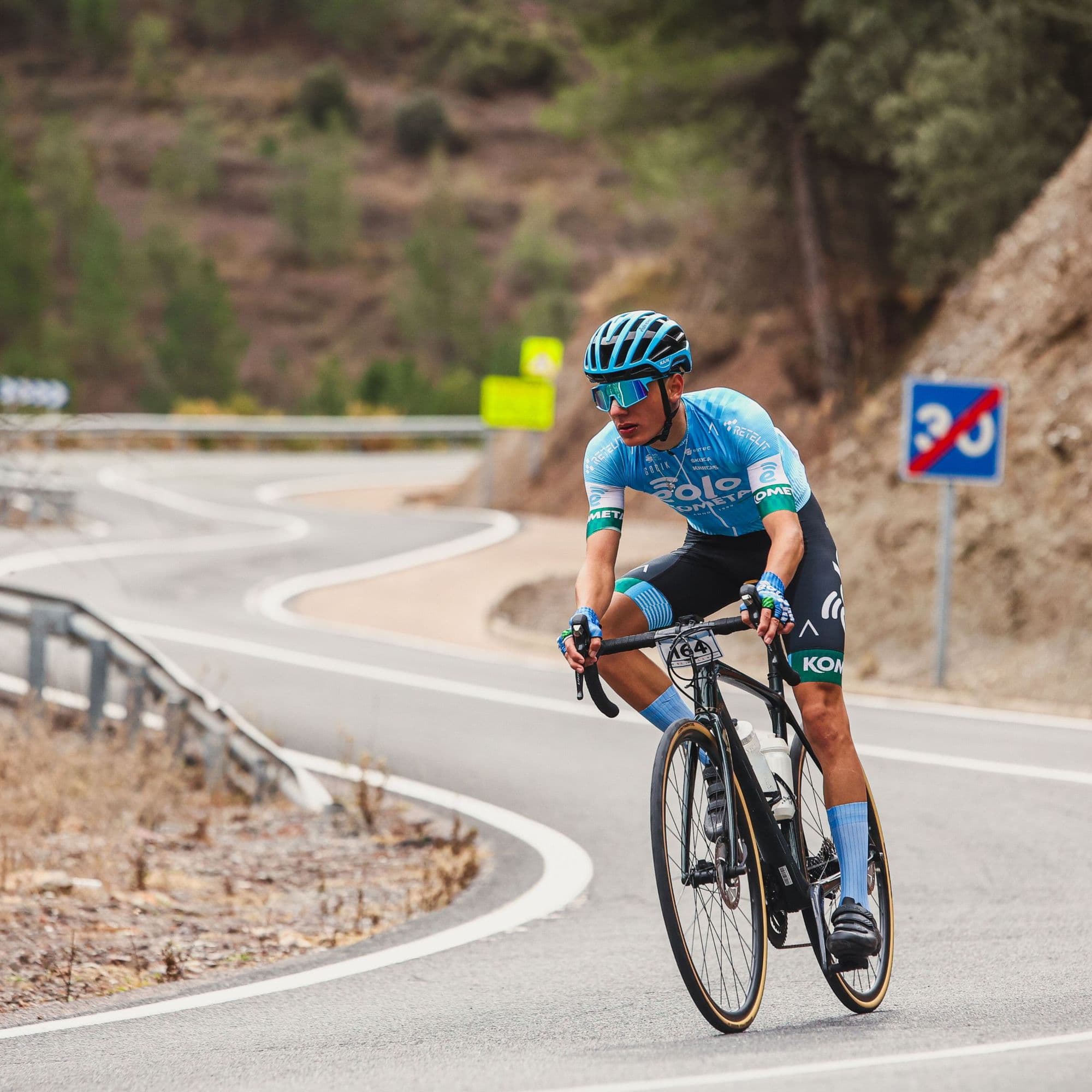 A road cyclist descending a mountain pass on a switchback road